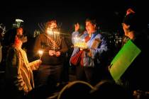 Members of the community gathered at the Lake Merritt Amphitheater in Oakland, Calif., to light ...