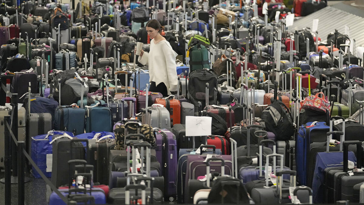 FILE - A woman walks through unclaimed bags at Southwest Airlines baggage claim at Salt Lake Ci ...