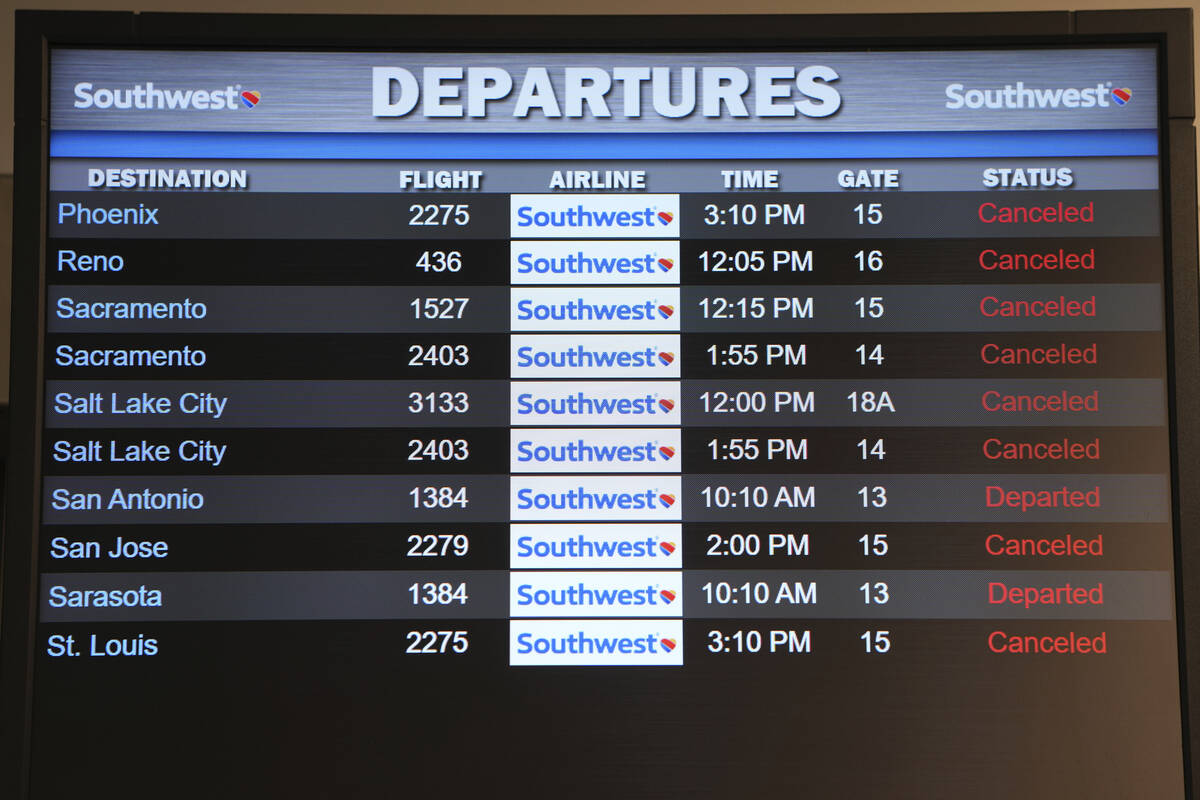FILE - Canceled Southwest Airlines flights are displayed in red on the departures monitor at th ...