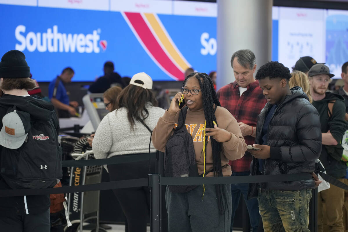FILE - Travelers wait in line for service at the Southwest Airlines check-in counter at Denver ...