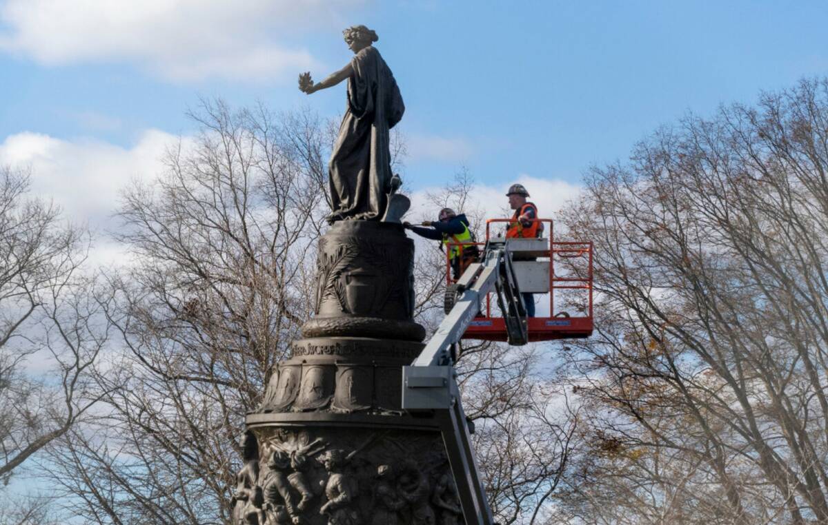 Workers prepare a Confederate Memorial for removal in Arlington National Cemetery on Monday, De ...