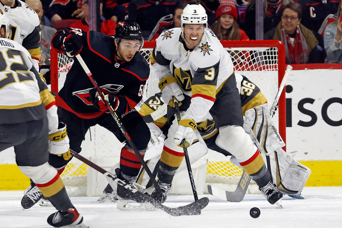 Vegas Golden Knights' Paul Cotter (43) tries to pass the puck around Carolina Hurricanes' Jespe ...