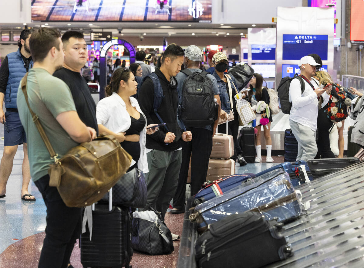 Arriving passengers wait for their luggage at the baggage claim area at Terminal 1 of Harry Rei ...