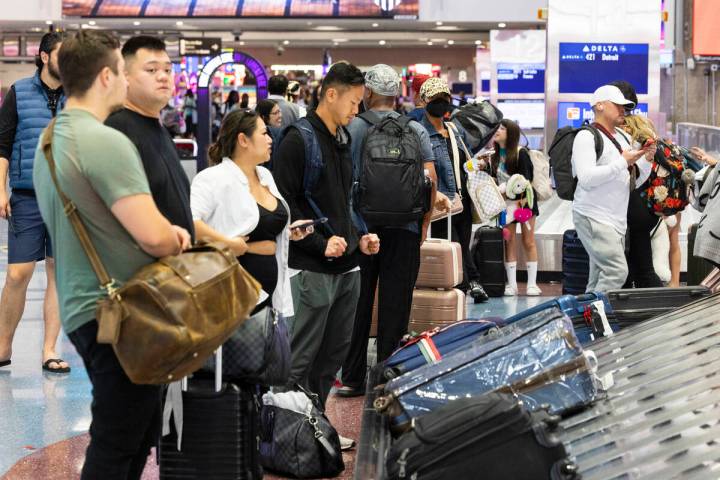 Arriving passengers wait for their luggage at the baggage claim area at Terminal 1 of Harry Rei ...