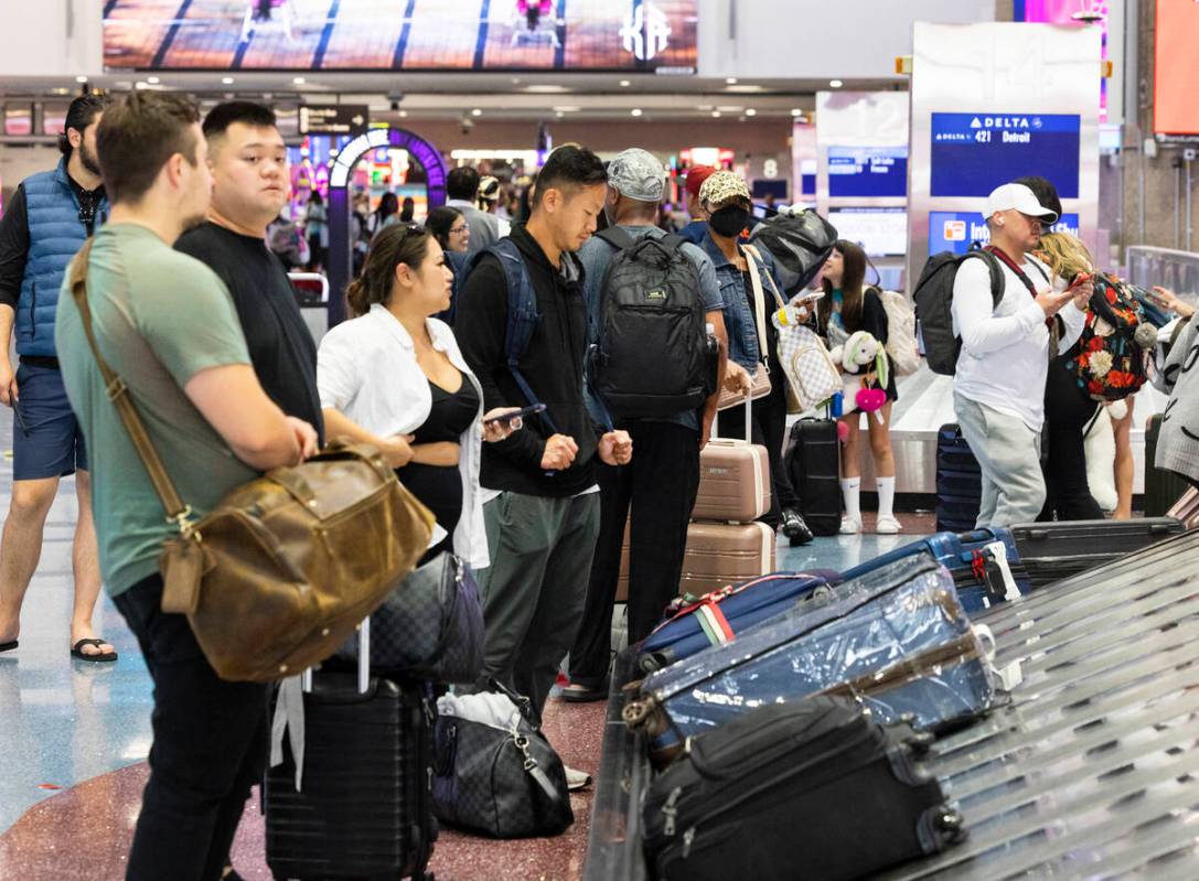 Arriving passengers wait for their luggage at the baggage claim area at Terminal 1 of Harry Rei ...