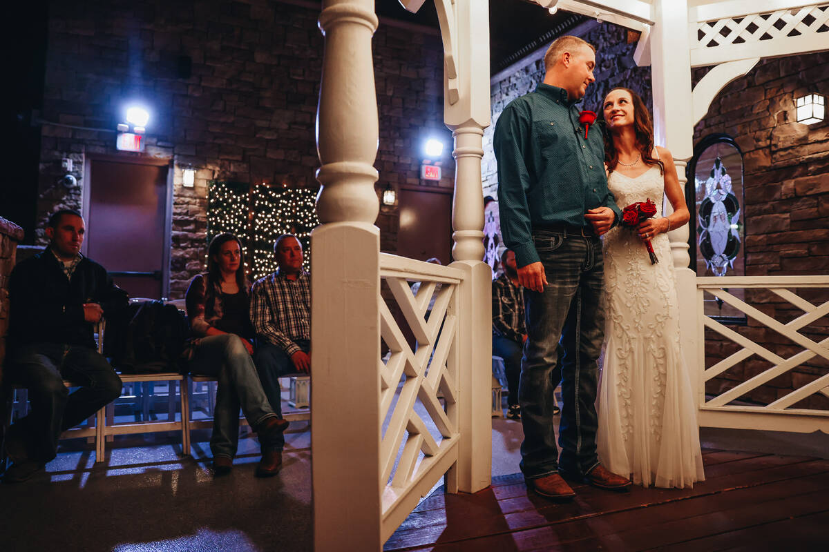 Kent Hagerman, left, and Kendra Smith lock arms during their wedding ceremony at Vegas Weddings ...