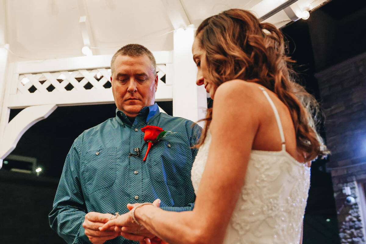 Kent Hagerman, left, slips a wedding ring on Kendra Smith’s finger during their wedding ...