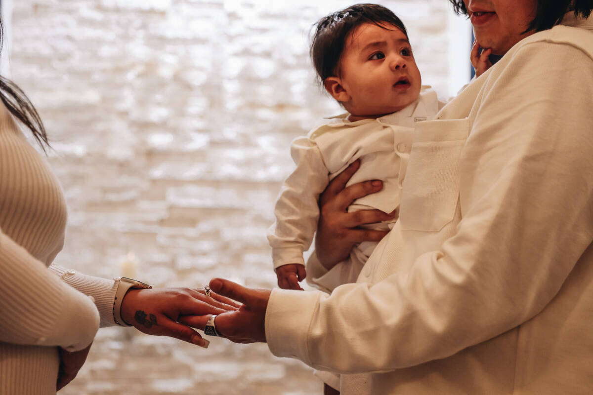 Rudolfo Corlew, right, and Natalie Mazariegos exchange wedding rings with their son, Michelange ...