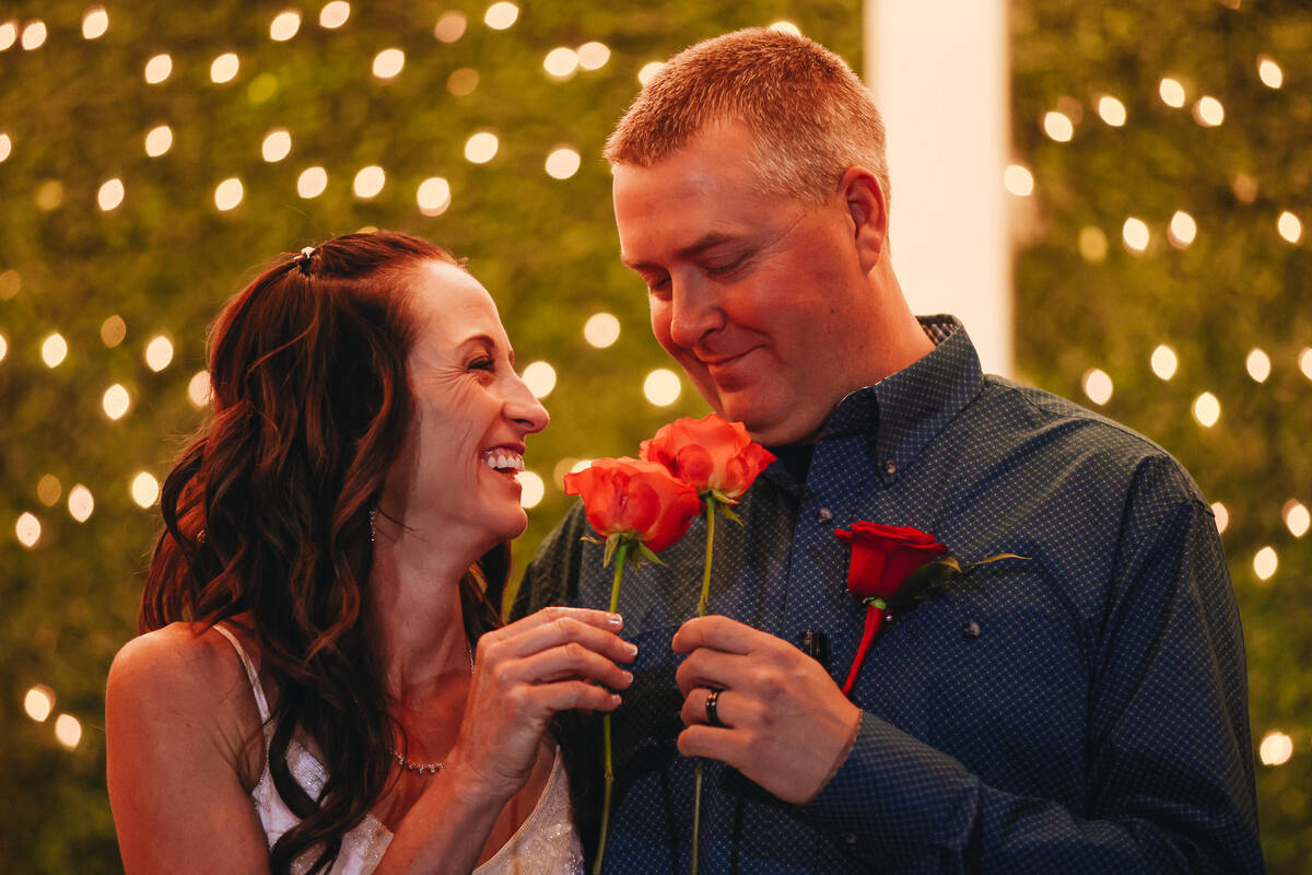 Kendra Smith, left, looks at Kent Hagerman as they hold roses during their wedding ceremony at ...