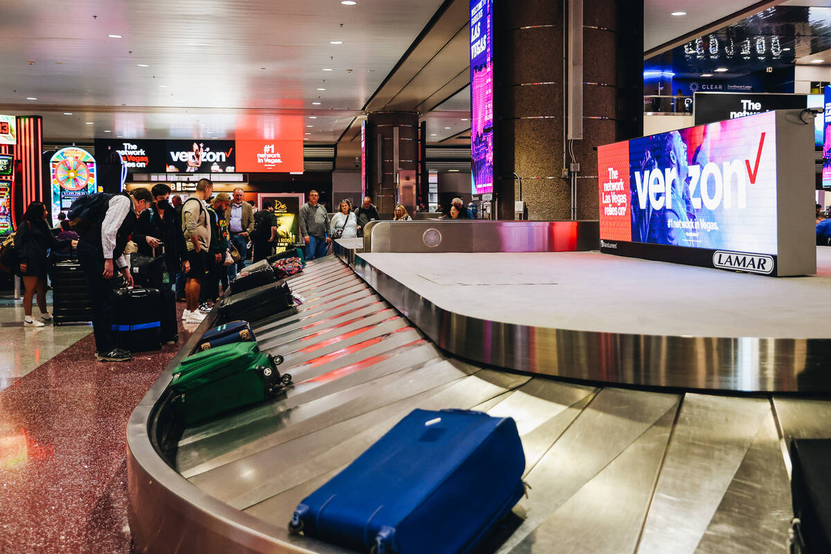 Travelers wait to pick up their bags at the baggage claim area at Harry Reid International Airp ...