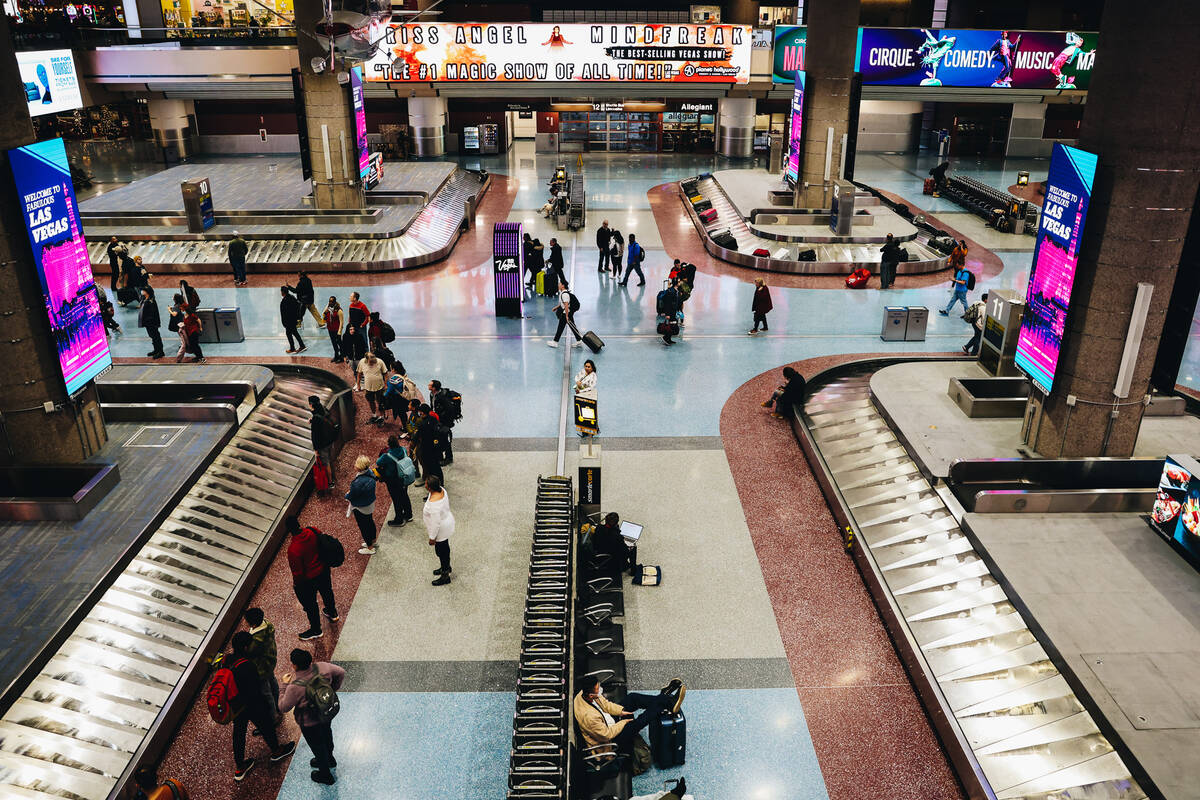 Travelers wait to pick up their bags at the baggage claim area at Harry Reid International Airp ...