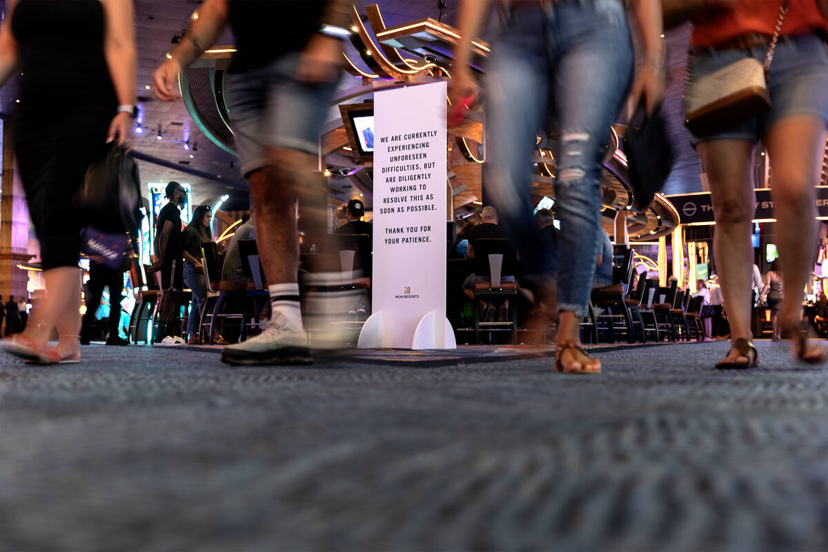 Guests walk through New York New York past a sign about MGM’s “unforeseen difficu ...