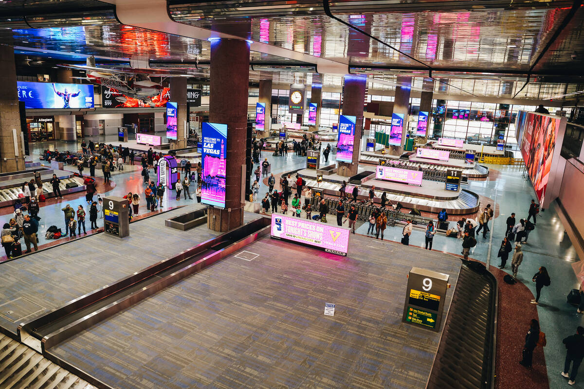 Travelers wait to pick up their bags at the baggage claim area at Harry Reid International Airp ...