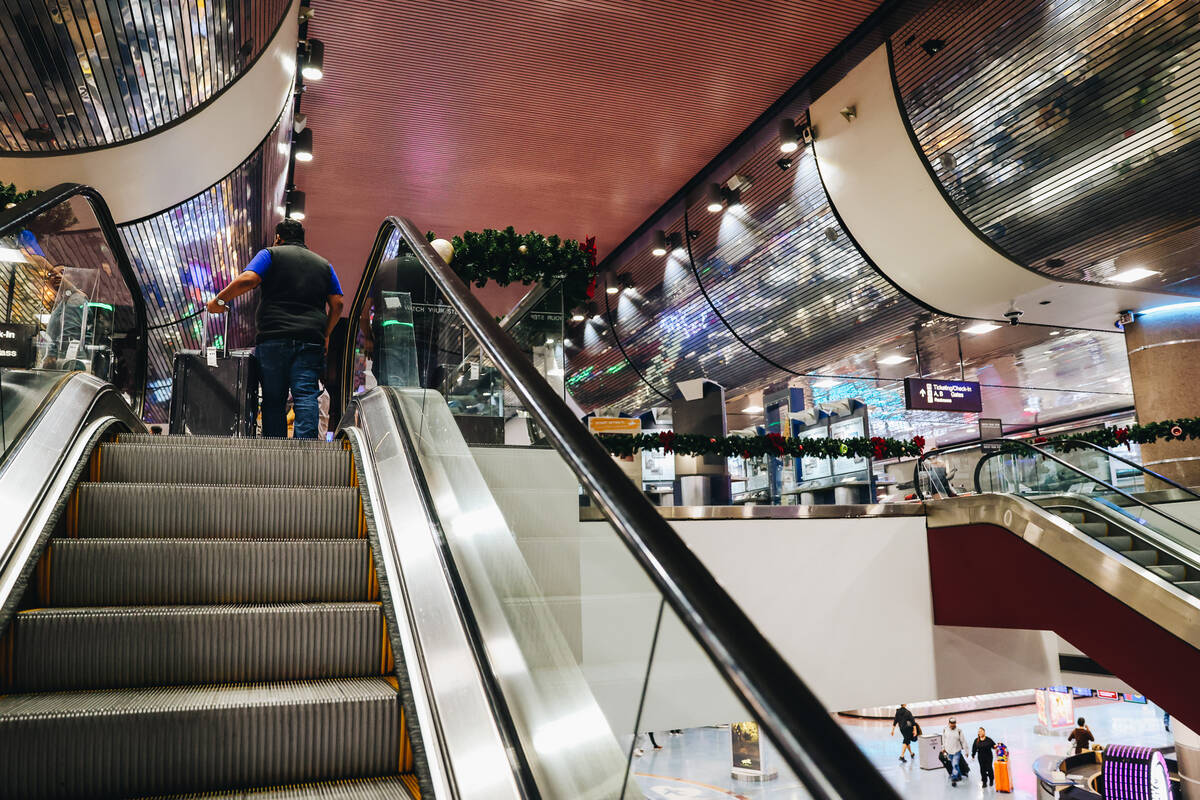 A traveler rides the escalator at Harry Reid International Airport on Wednesday, Dec. 20, 2023, ...