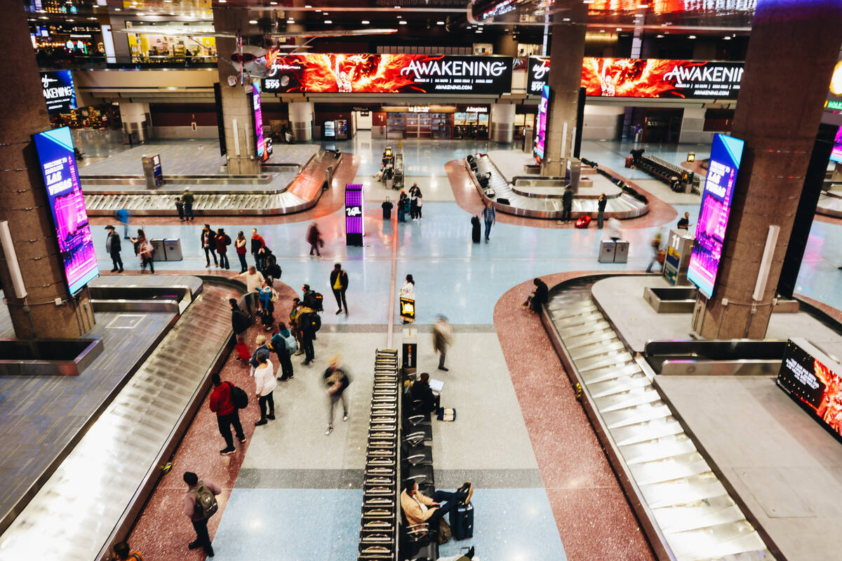 Travelers wait to pick up their bags at the baggage claim area at Harry Reid International Airp ...