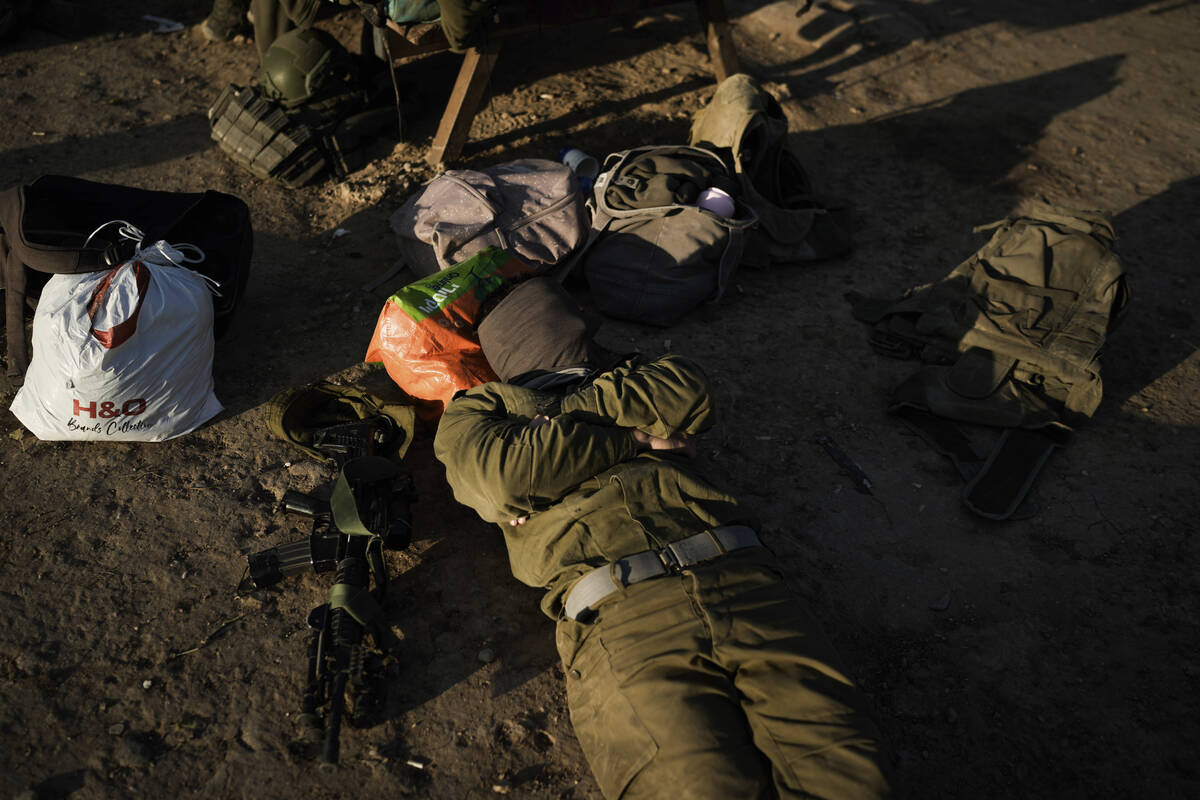 An Israeli soldier rests at a staging area near the Israeli-Gaza border, southern Israel, Tuesd ...