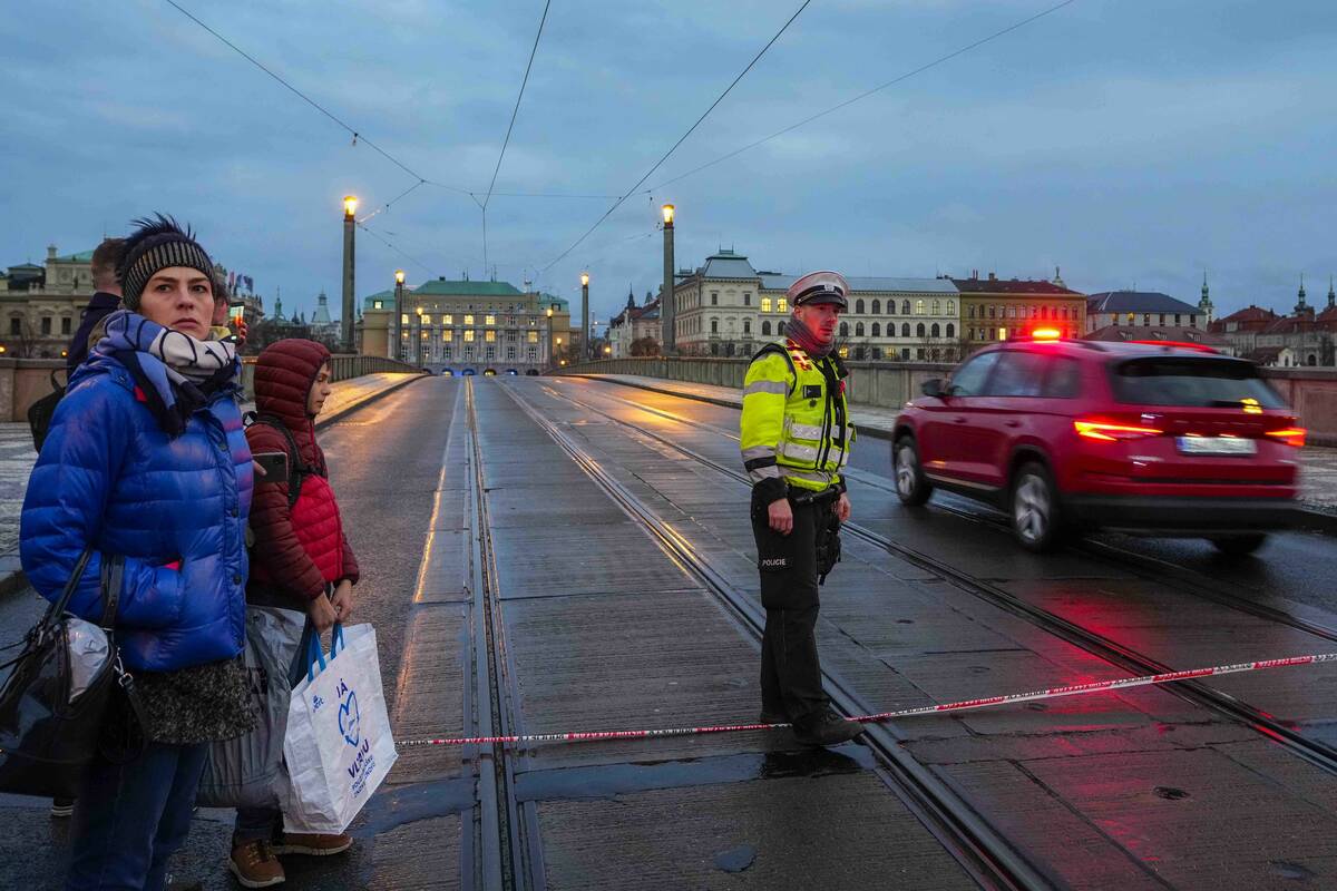 A police officer guards a street after a shooting in downtown Prague, Czech Republic, Thursday, ...