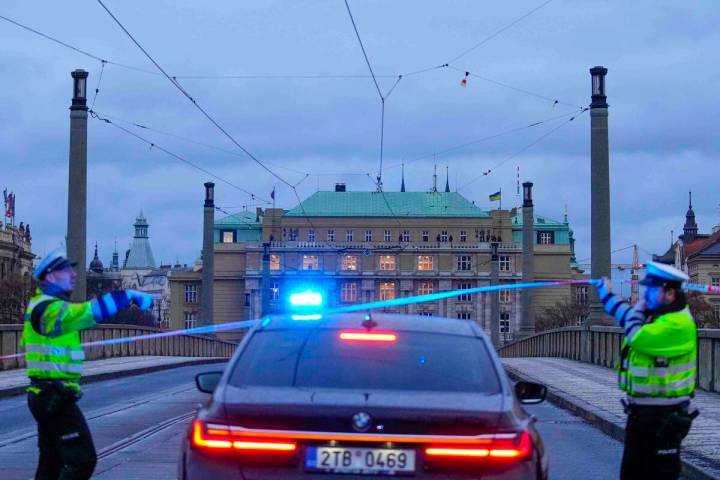 Police officers guard a street in downtown Prague, Czech Republic, following a mass shooting Th ...