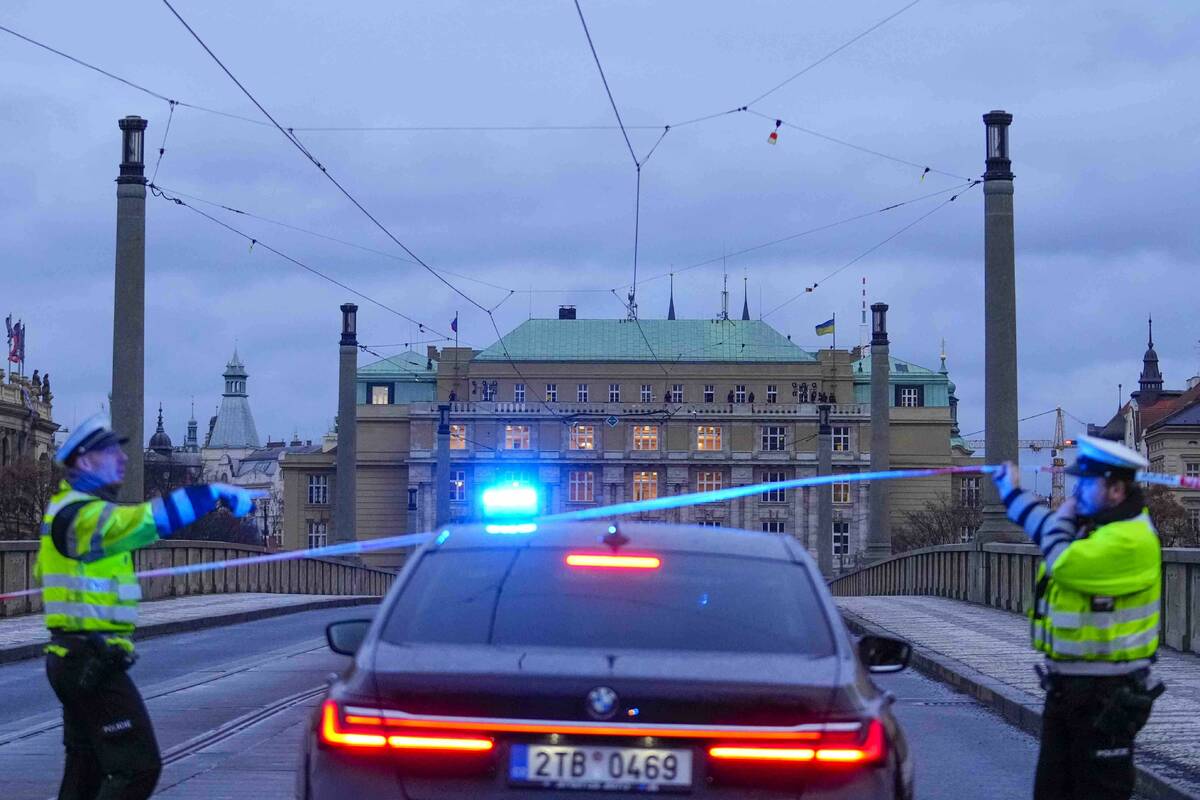 Police officers guard a street in downtown Prague, Czech Republic, following a mass shooting Th ...