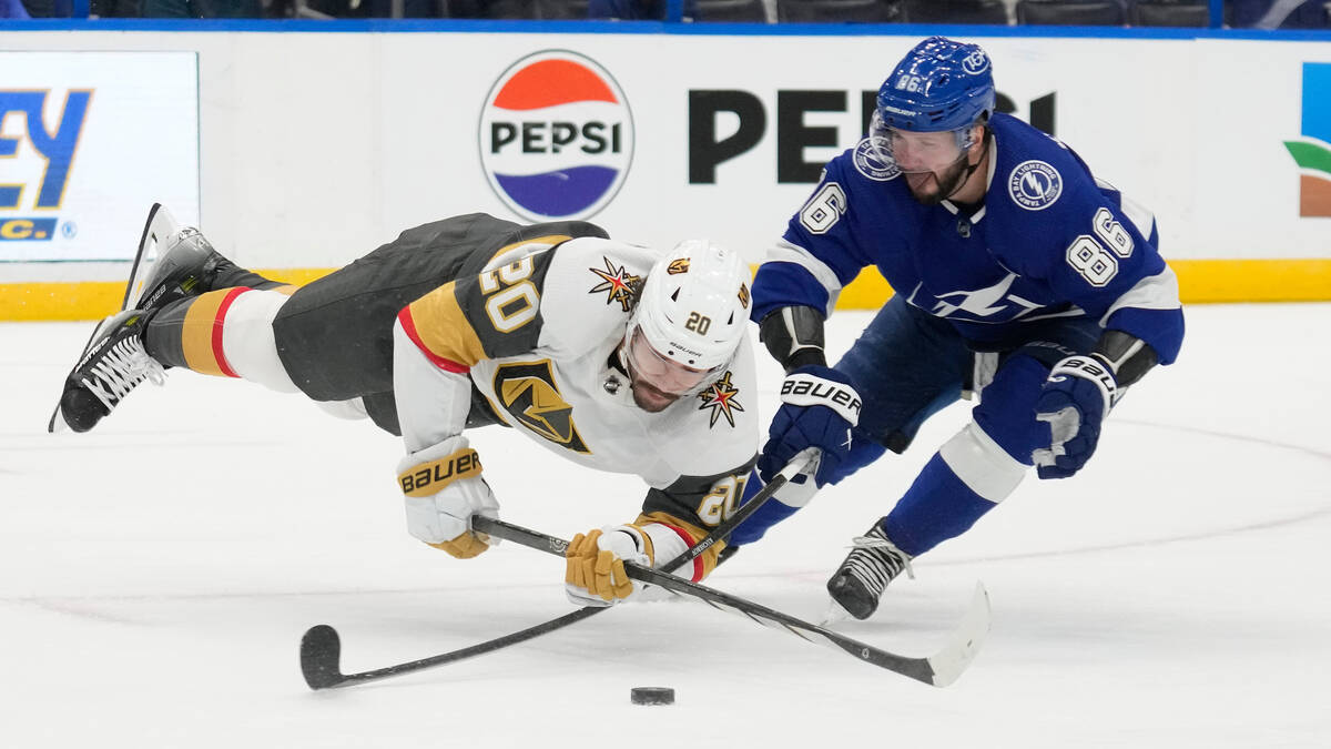 Vegas Golden Knights center Chandler Stephenson (20) gets tripped by Tampa Bay Lightning defens ...