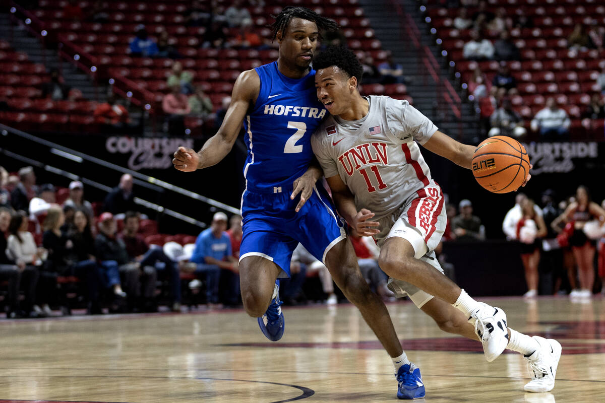 UNLV Rebels guard Dedan Thomas Jr. (11) drives past Hofstra Pride guard Bryce Washington (2) du ...