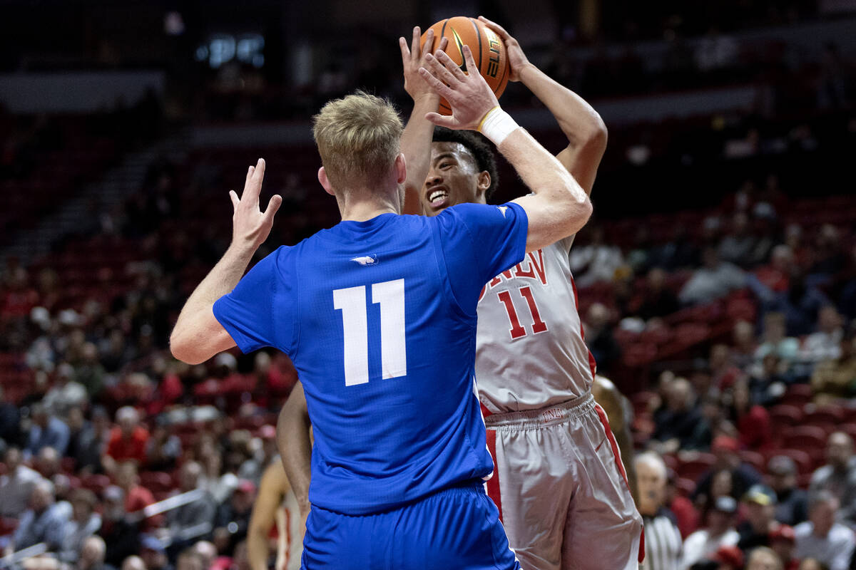 UNLV Rebels guard Dedan Thomas Jr. (11) pivots from a shot to pass against Hofstra Pride forwar ...