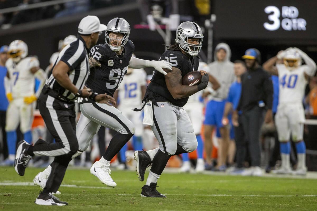 Raiders defensive tackle John Jenkins (95) runs with defensive end Maxx Crosby (98) after recov ...