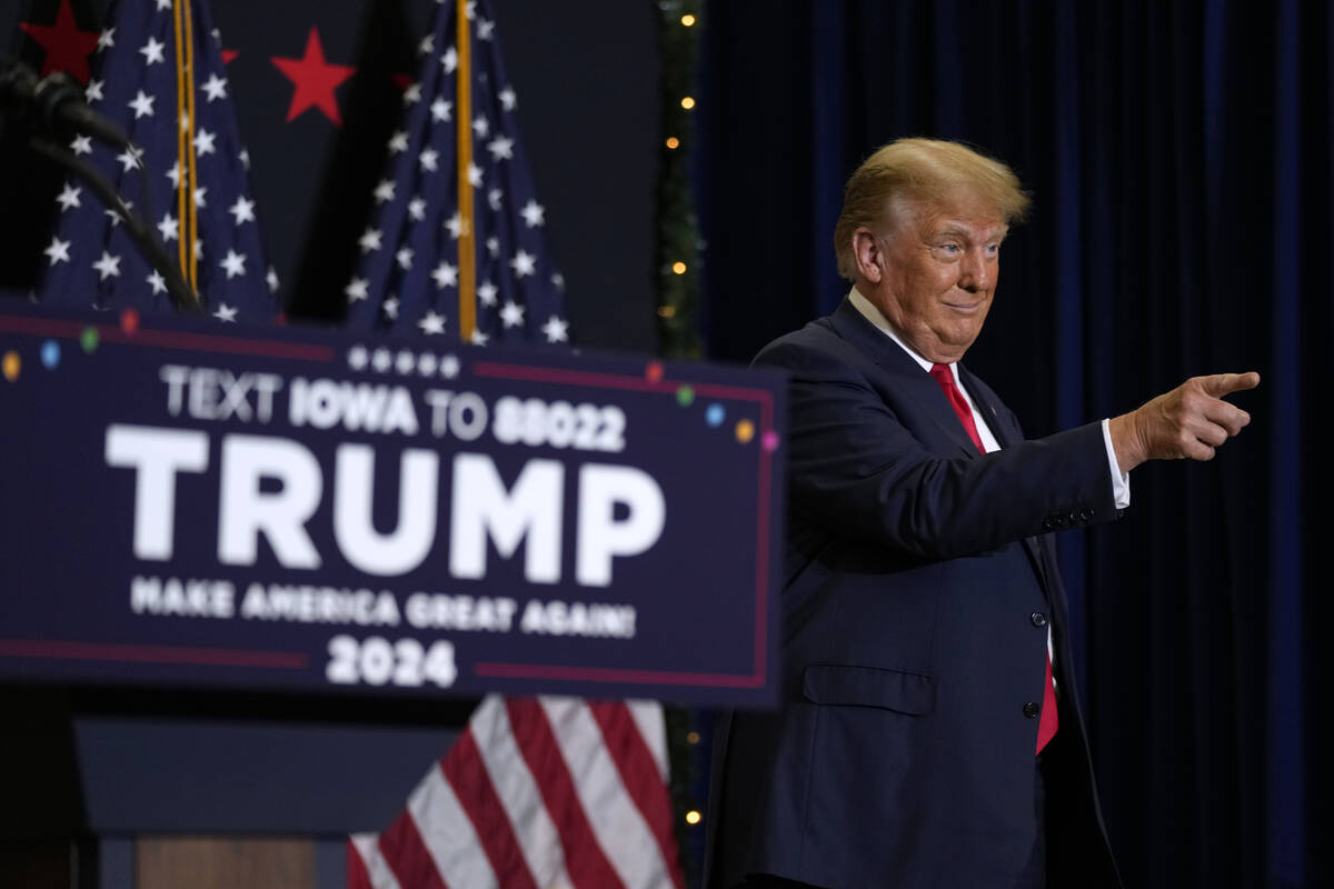 Former President Donald Trump greets supporters as he arrives at a commit to caucus rally, Tues ...