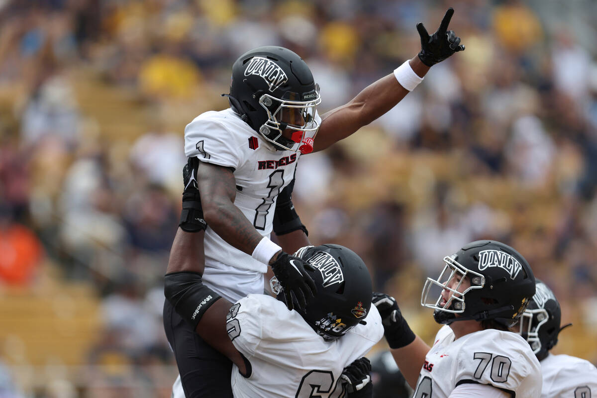 UNLV's Kyle Williams (1) celebrates with Amani Trigg-Wright (60) and Tiger Shanks (70) after sc ...