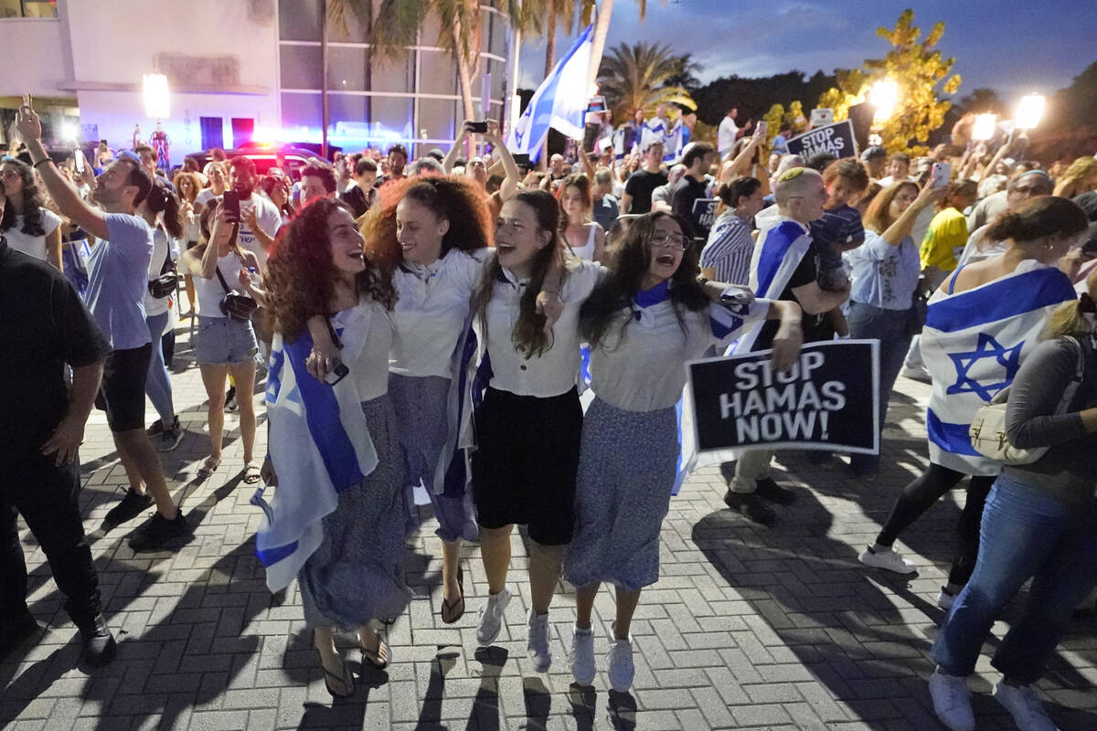 FILE - A group of Israeli girls jump and sing as they attend a rally in support of Israel, at t ...