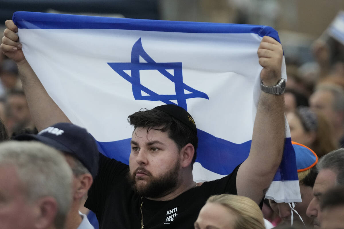 FILE - A man holds up an Israeli flag as he attends a rally in support of Israel, at the Holoca ...