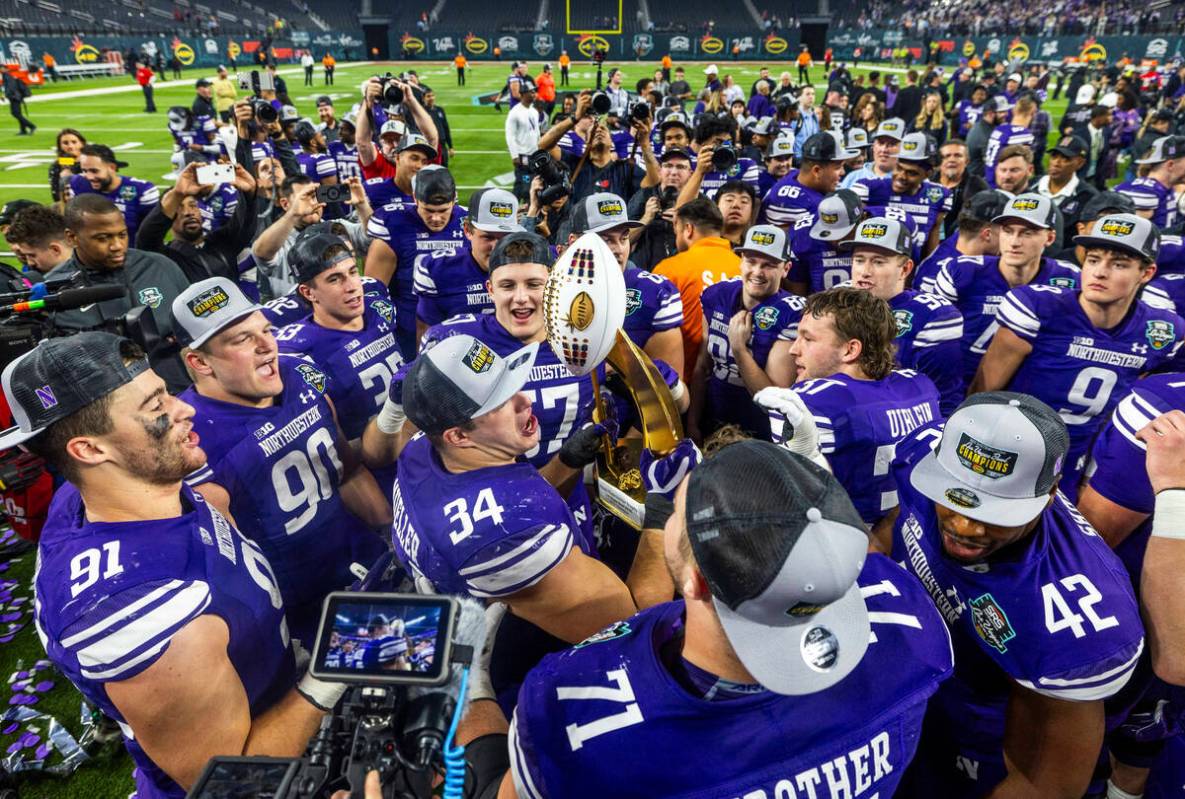 Northwestern Wildcats players celebrate their win with the trophy defeating the Utah Utes 14-7 ...