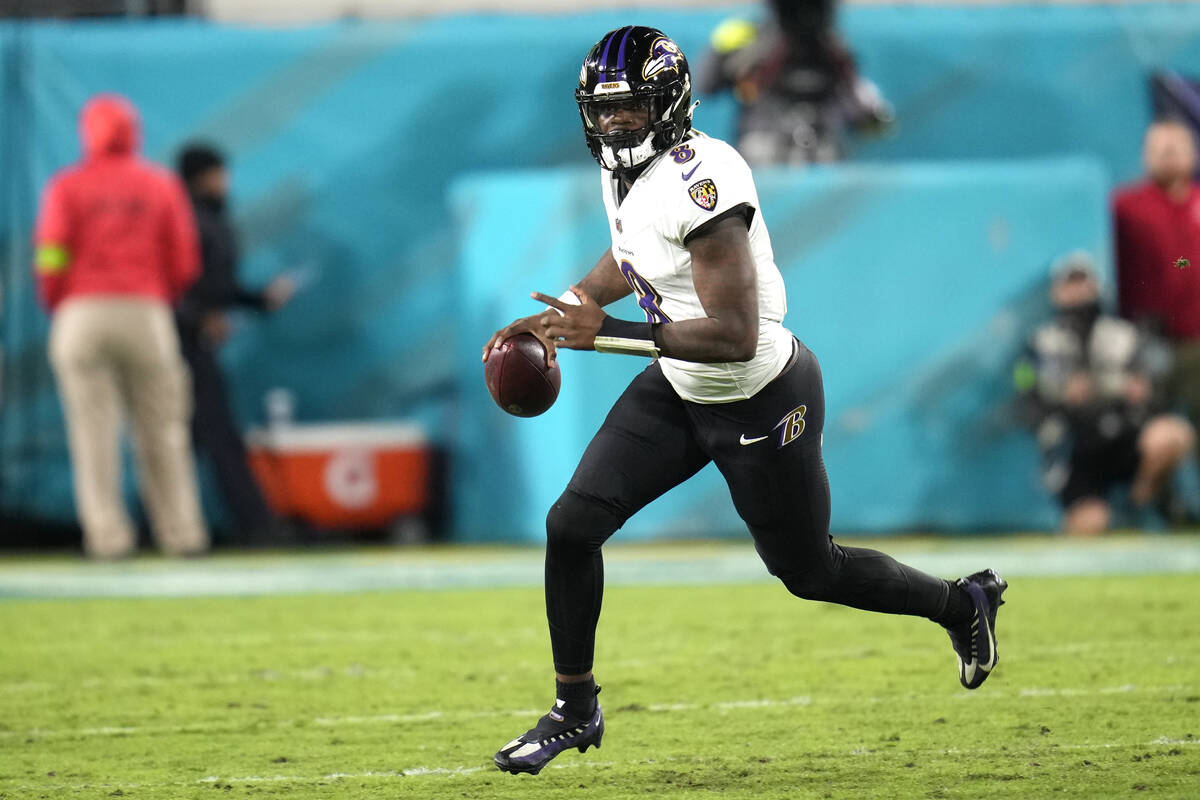 Baltimore Ravens quarterback Lamar Jackson (8) scrambles out of the pocket during the first hal ...