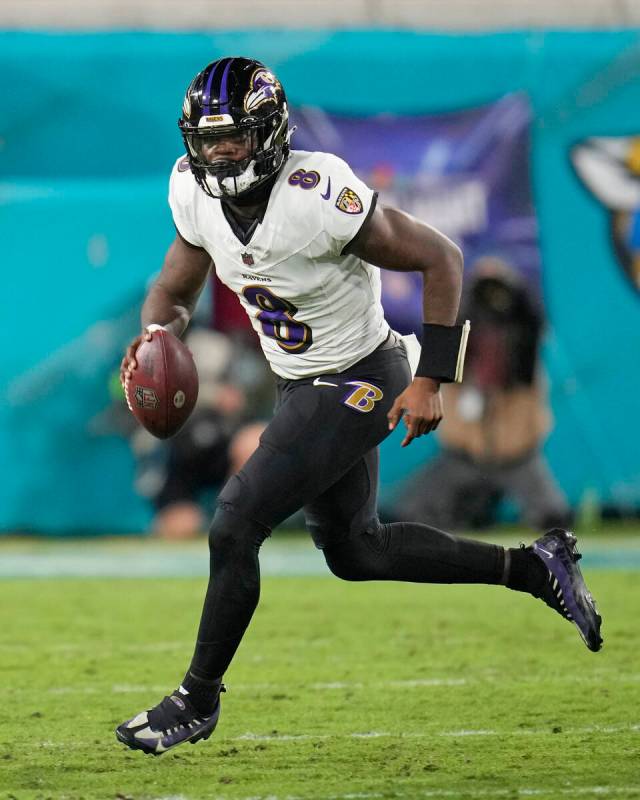 Baltimore Ravens quarterback Lamar Jackson (8) scrambles out of the pocket during the first hal ...