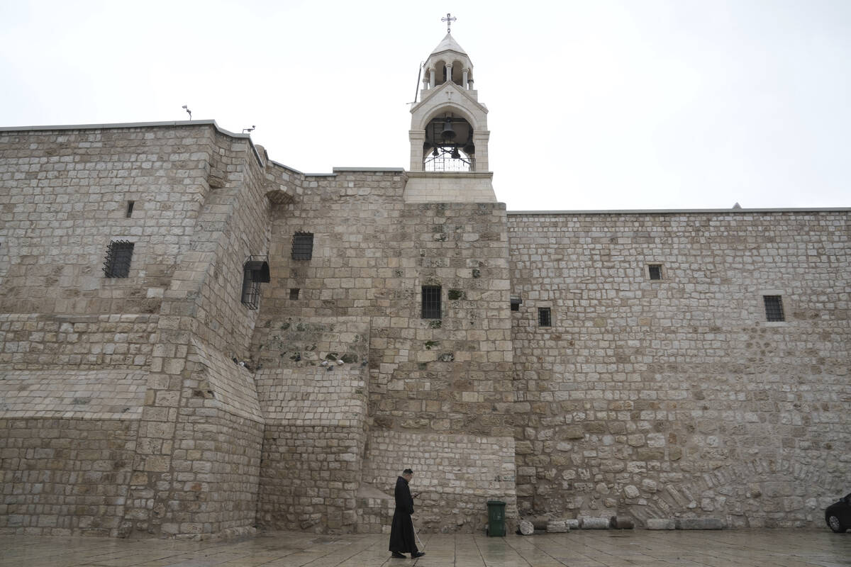 A priest walks by the Church of the Nativity, traditionally believed to be the birthplace of Je ...