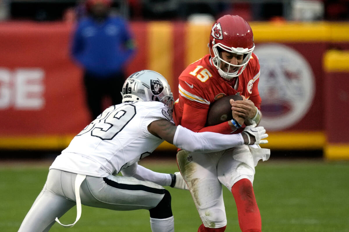 Kansas City Chiefs quarterback Patrick Mahomes (15) is stopped by Las Vegas Raiders cornerback ...