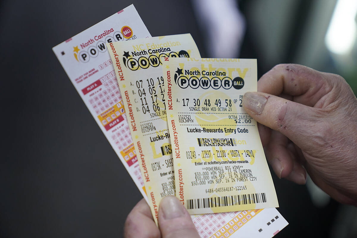 Rick Willems shows the Powerball tickets that he purchased at Cigarettes and More on Wednesday, ...
