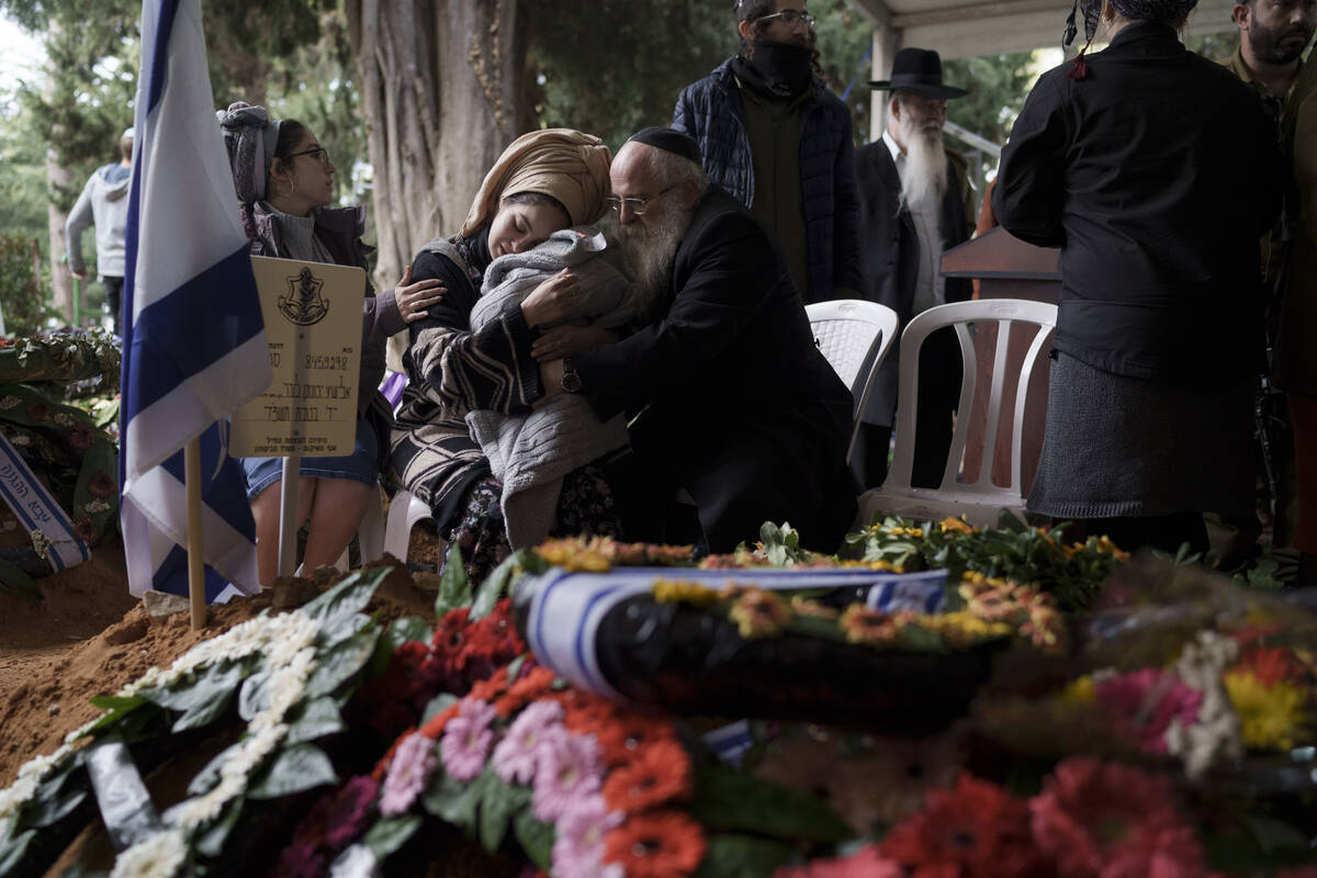 The wife, center, of the Israeli staff sergeant Elisha Yehonatan Lober, who was killed in battl ...