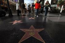 Visitors walk towards Donald Trump's star on the Hollywood Walk of Fame in Los Angeles on Dec. ...