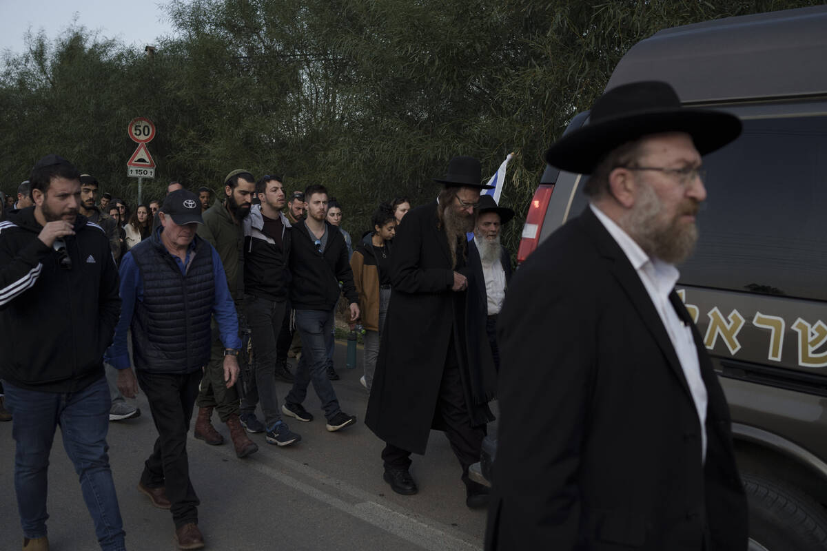 Relatives and friends of the Israeli Captain Neriya Zisk, follow his funeral procession as they ...