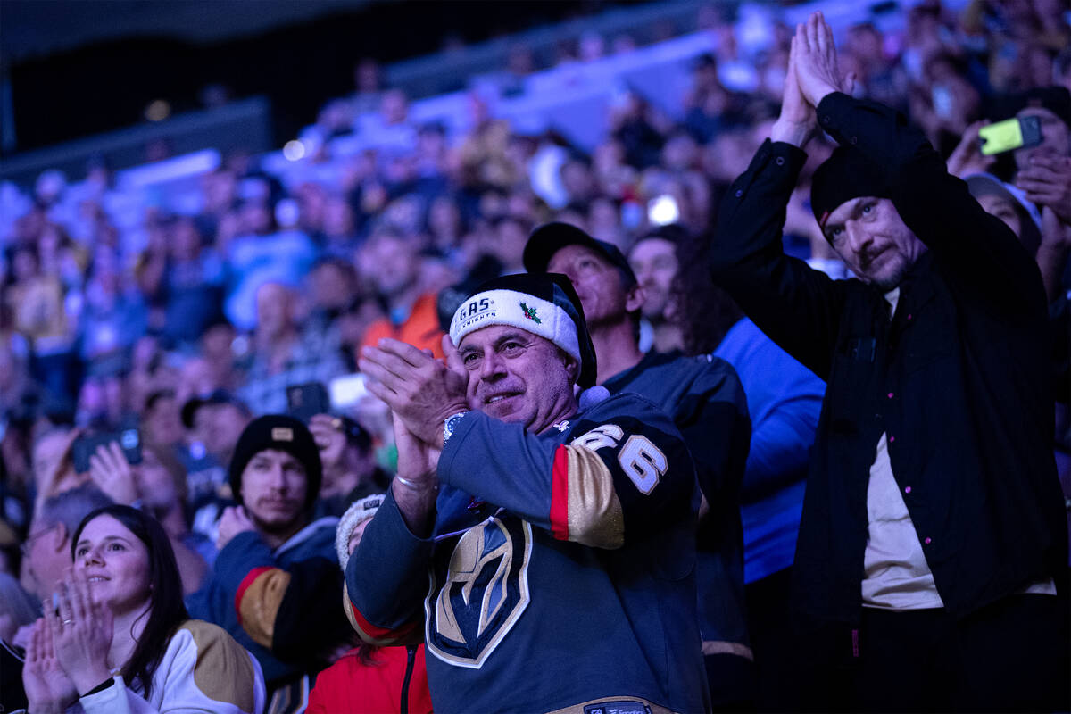 A Golden Knights fan, wearing a Santa hat, celebrates as the team takes the ice before an NHL h ...