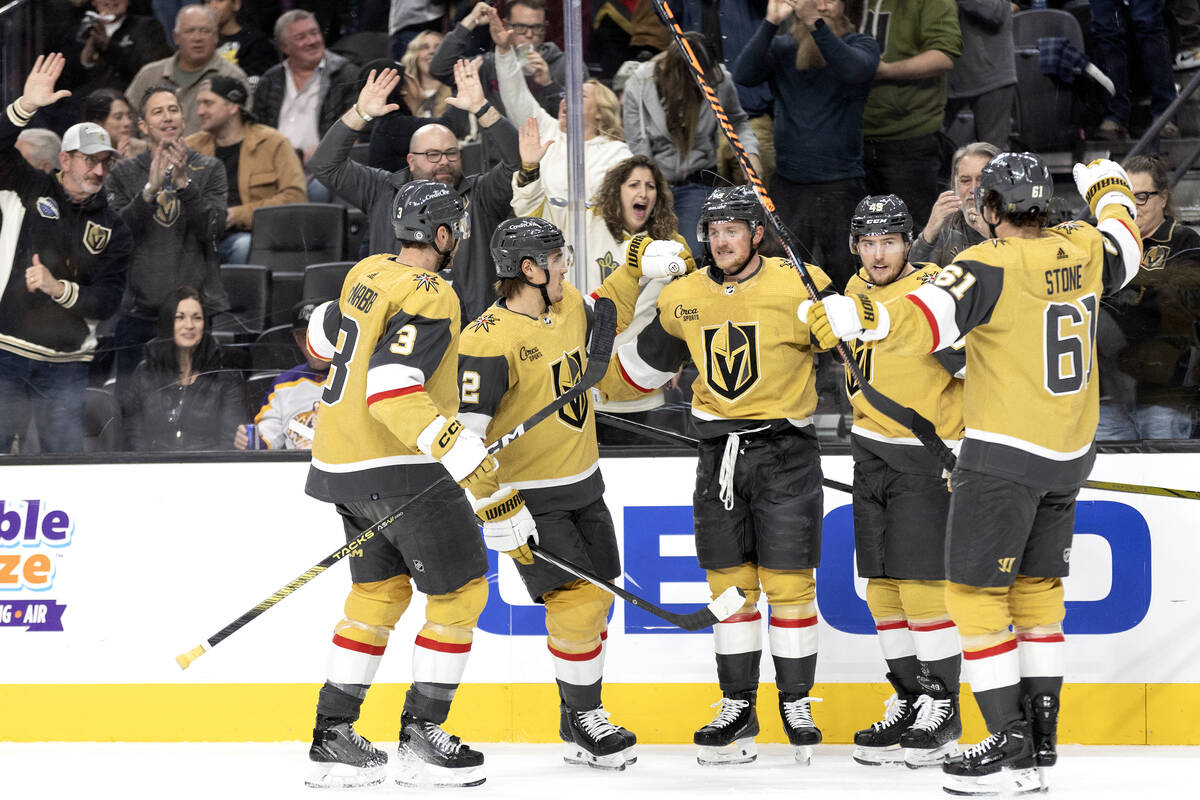 The Golden Knights surround center Jack Eichel (9) after he scored during the first period of a ...