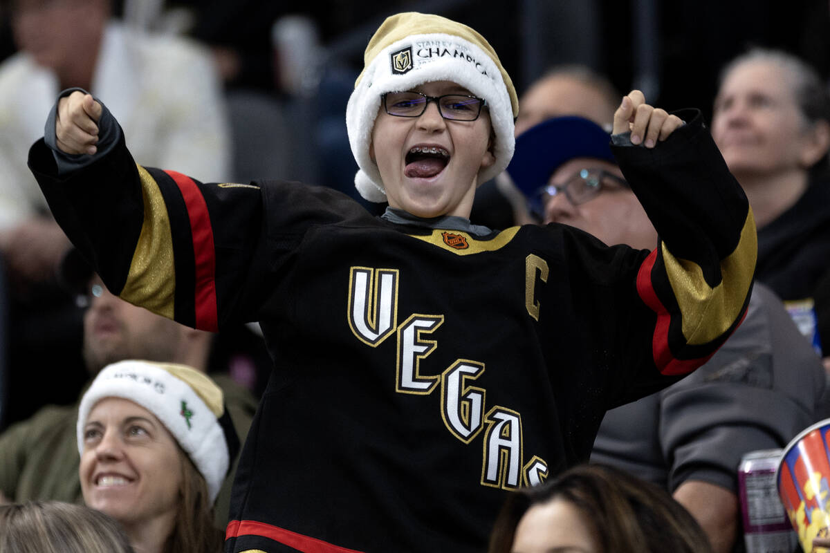 A young Golden Knights fan cheers to get on the big screen during the first period of an NHL ho ...