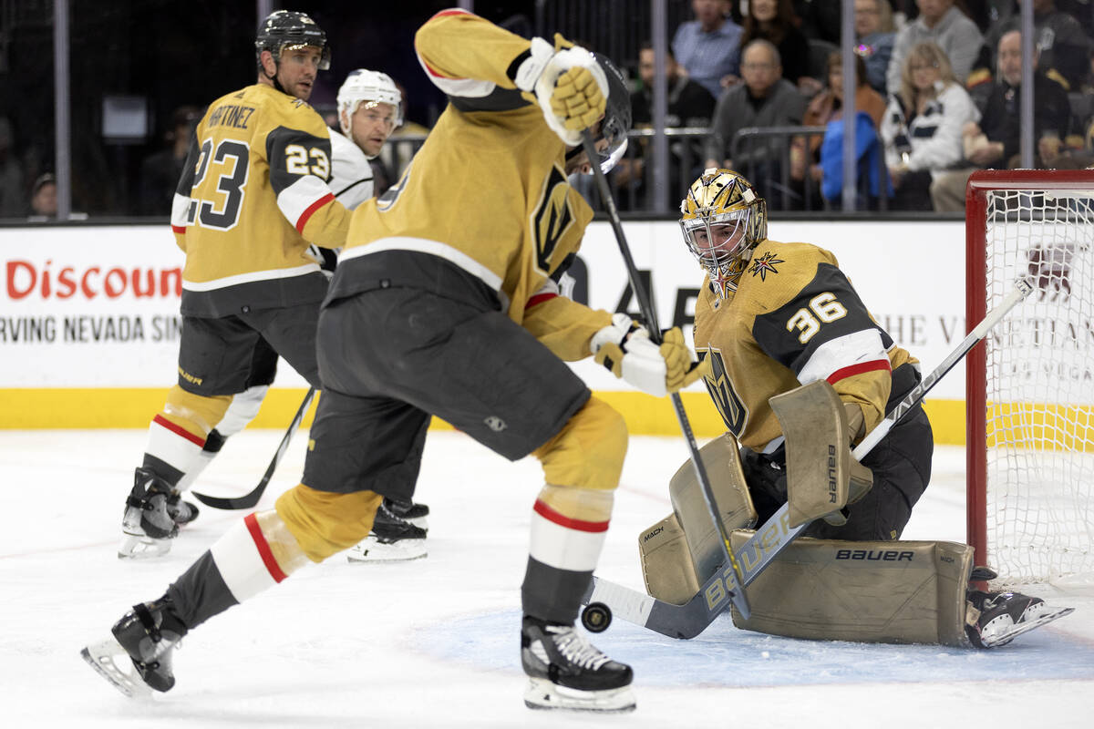 Golden Knights goaltender Logan Thompson (36) and defenseman Nicolas Hague (14) get the puck aw ...