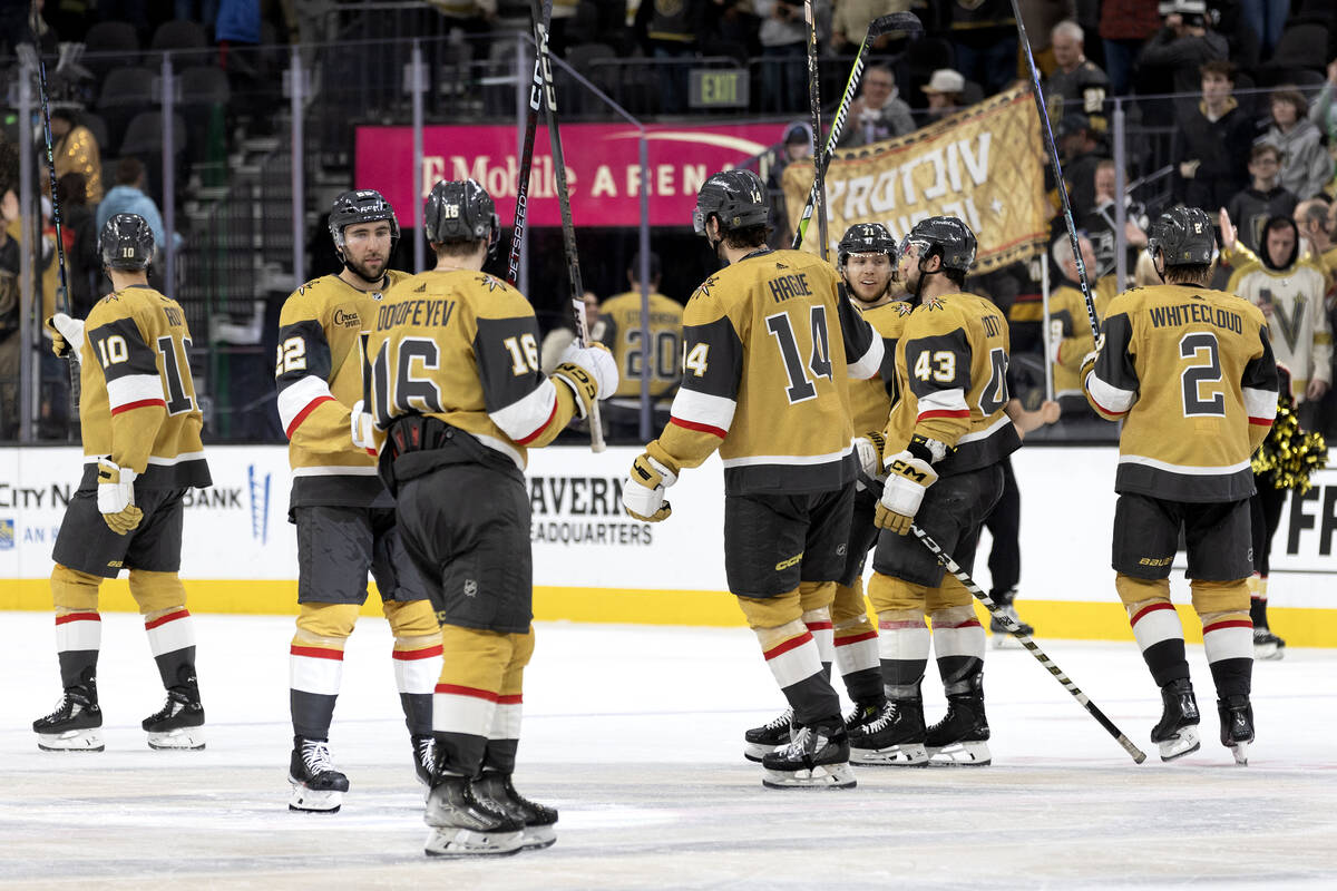 The Golden Knights hold their sticks up after winning an NHL hockey game against the Kings at T ...