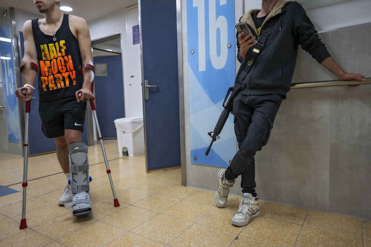 An Israeli soldier wounded in the war with Hamas walks with crutches in the rehabilitation divi ...