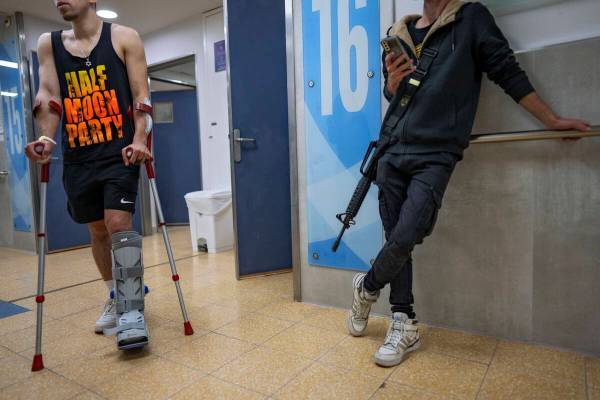 An Israeli soldier wounded in the war with Hamas walks with crutches in the rehabilitation divi ...