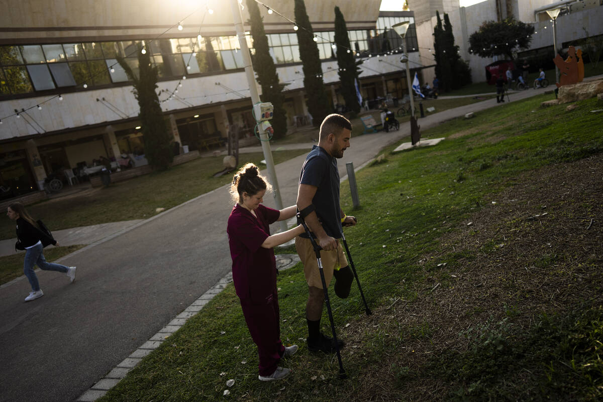 Israeli soldier Jonathan Ben Hamou, 22, wounded in the war with Hamas, practices walking with c ...