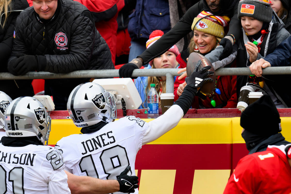 Las Vegas Raiders cornerback Jack Jones (18) looks to give the football to a kid after scoring ...