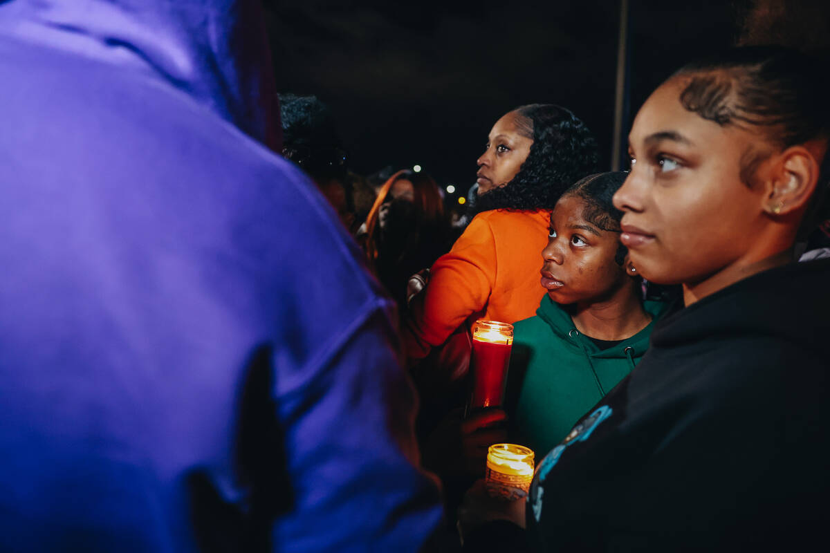 Mourners hold candles during a vigil for Keon Young at Desert Horizons Park on Friday, Dec. 29, ...